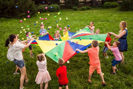 Kinder spielen auf einer Wiese im Kreis