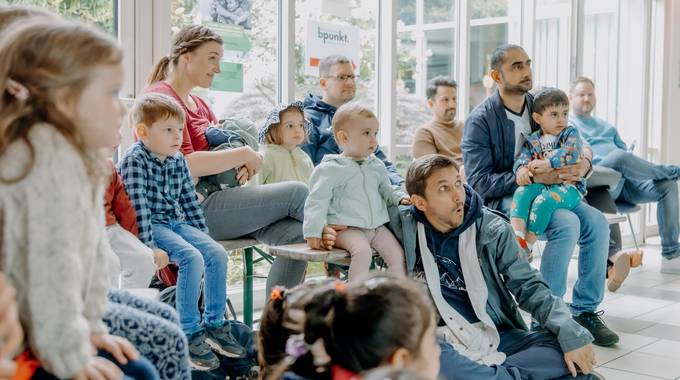 Väter und Kinder sitzen im Rathaus und nehmen am Familienprogramm teil