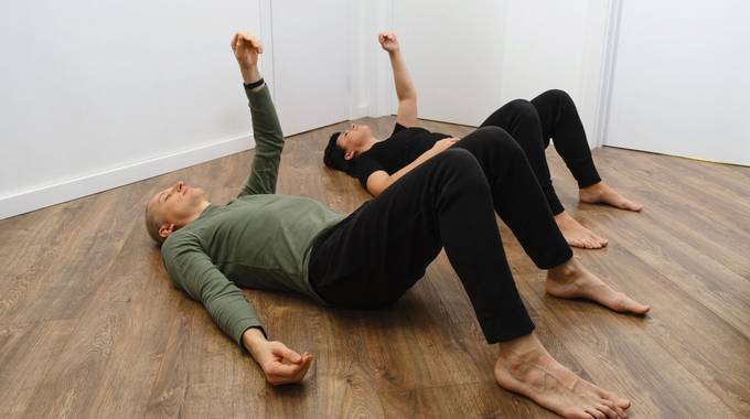 Gymnastik auf dem Boden © Ninelutsk - stock.adobe.com Zwei Personen liegen auf dem Holzboden und machen Gymnastik