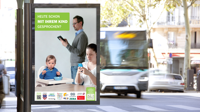 Plakat an einer Bushaltestelle: Eltern beschäftigen sich nicht mit ihrem Kleinkind am Esstisch, sondern mit ihren Handy