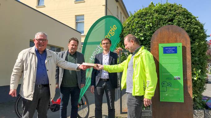 Rüdiger Ratzke (li.) und Herbert Fischer (re.) vom Verein „De dollen Dörfler” freuen sich mit Bürgermeister Lutz Wagner und Thomas Krischik von der Westenergie AG über die Eröffnung des neuen Bücherschranks.