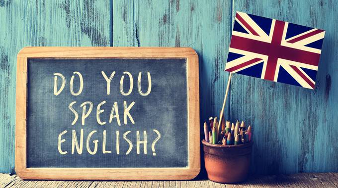 Tafel mit "Do you speak english" und britischer Fahne im Hintergrund