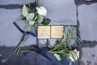 Zwei Stolpersteine mit weißen Rosen