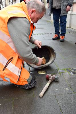 Ein Mitarbeiter des Bauhofs bringt den Stein ins Pflaster ein