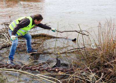 Bürgermeister Lutz Wagner hat im Rheinhochwasser eine Plastikflache entdeckt