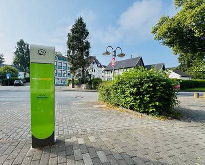 Grüne Ladesäule auf einem Parkplatz