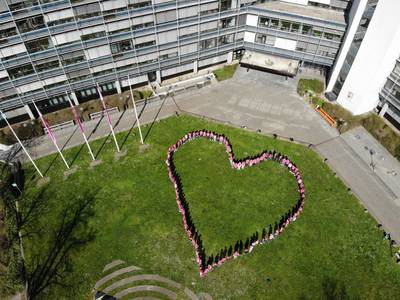 Mitarbeiter des Kreises, die Bürgermeisterinnen und Bürgermeister stehen in einem Herz und tragen pinke Shirts