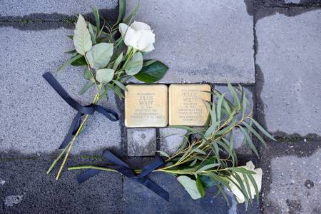 Zwei Stolpersteine mit weißen Rosen