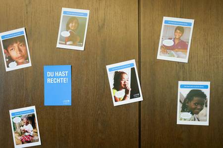 Postkarten zum Thema Kinderschutz hängen an einer Wand