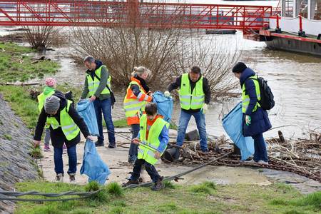 Am Rheinufer Königswinter-Altstadt wurde durch das Hochwasser Einiges angeschwemmt. Bürgermeister Lutz Wagner, Dezernentin Heike Jüngling und Mitarbeitende mit Kindern sammeln den Müll ein.