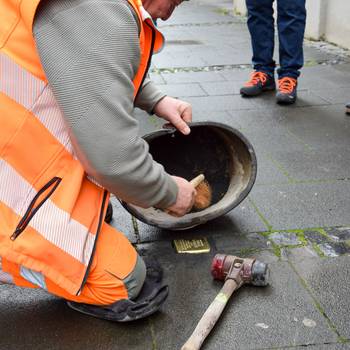 Ein Mitarbeiter des Bauhofs bringt den Stein ins Pflaster ein