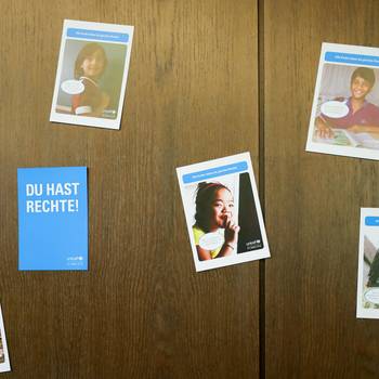 Postkarten zum Thema Kinderschutz hängen an einer Wand