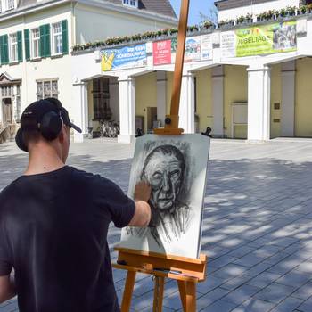Ein Künstler beim Wet Painting auf dem Rathausplatz Königswinter © Stadt Königswinter Das Kunstwerk konnte im Anschluss ersteigert werden
