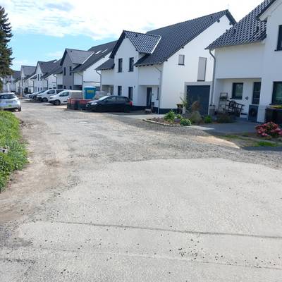 Abbildung des Straßenzustands des Lilienwegs, im Hintergrund Häuser