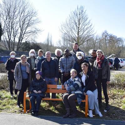 Eine der Bänke steht an der Bushaltestelle Haus Heisterbach, wo sich ein engagiertes Team von Mitarbeitenden und ehrenamtlich Helferenden tatkräftig bei der Begleitung von Gewalt betroffenen Frauen und deren Kinder einsetzt.