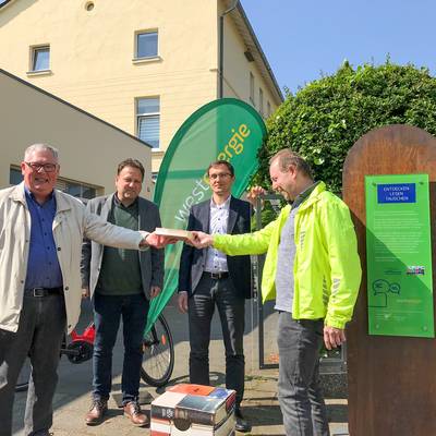 Rüdiger Ratzke (li.) und Herbert Fischer (re.) vom Verein „De dollen Dörfler” freuen sich mit Bürgermeister Lutz Wagner und Thomas Krischik von der Westenergie AG über die Eröffnung des neuen Bücherschranks.