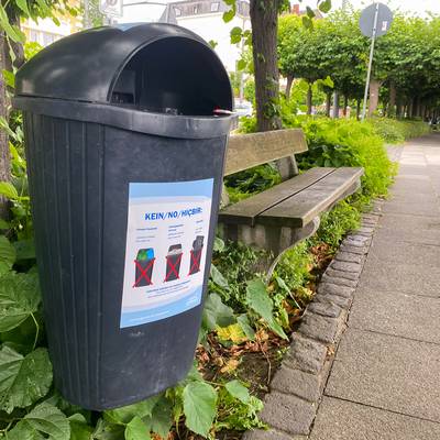 Aufkleber, die in mehreren Sprachen auf die richtige Nutzung der Mülleimer hinweisen