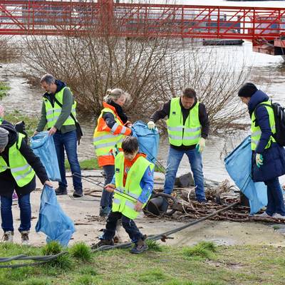 Am Rheinufer Königswinter-Altstadt wurde durch das Hochwasser Einiges angeschwemmt. Bürgermeister Lutz Wagner, Dezernentin Heike Jüngling und Mitarbeitende mit Kindern sammeln den Müll ein.