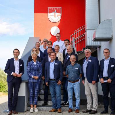 Landrat Sebastian Schuster (2.v.r.), Bürgermeister Lutz Wagner (8.v.r.), Schulleiterin Alexandra Weber (14.v.r.) und Michael Weber (TuS 05 Oberpleis, 9.v.r.), zusammen mit Ministerin Dorothee Feller (13 v.r.) mit allen Teilnehmenden des Besuches in Oberpleis.