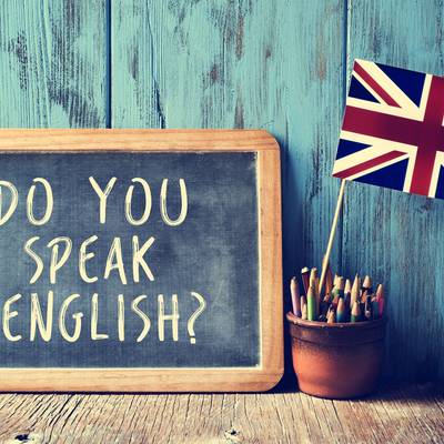 Tafel mit "Do you speak english" und britischer Fahne im Hintergrund