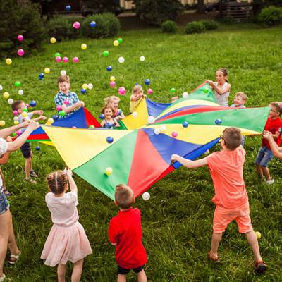 Kinder spielen auf einer Wiese im Kreis