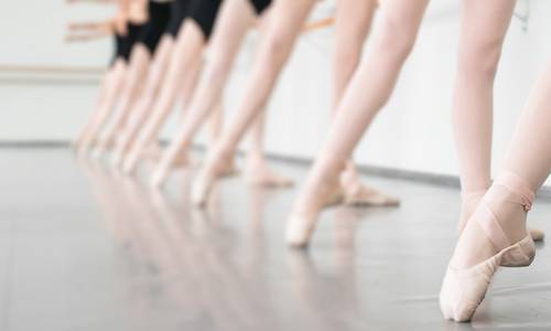 Ausschnitt, der Beine in Ballettoutfits zeigt