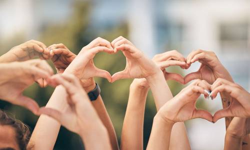 Hände formen Herzen in der Luft