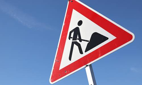 Baustellenschild vor blauem Himmel