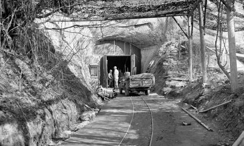 Mit einem Tarnnetz überspannter Eingang der sogenannten Aero-Stahl-Grube im März 1945 bei der Begutachtung durch US-Truppen.