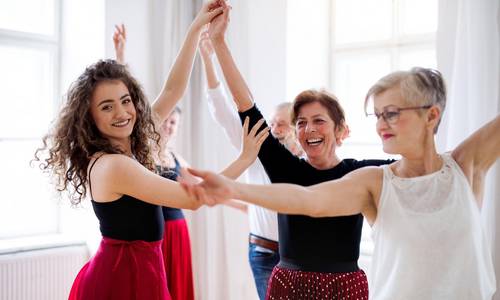 adobestock 291519681 halfpoint group of senior people in dancing class with dance teacher