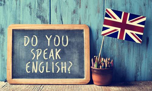 Tafel mit "Do you speak english" und britischer Fahne im Hintergrund