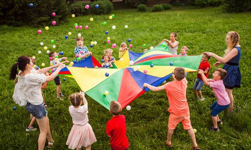 Kinder spielen auf einer Wiese im Kreis