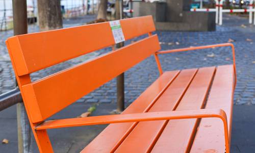 Orangefarbene Bank an der Rheinallee