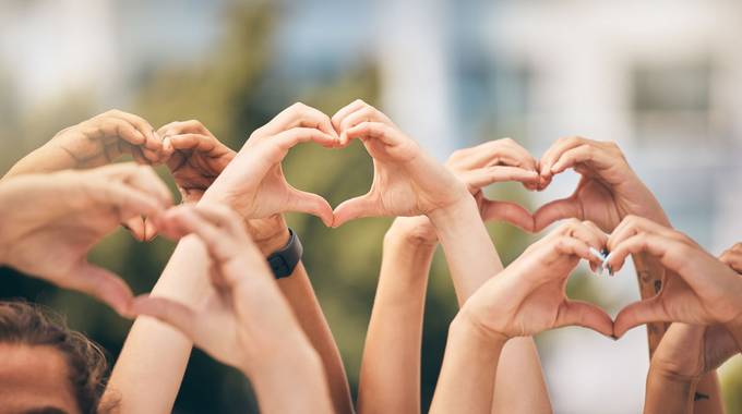 Hände formen Herzen in der Luft