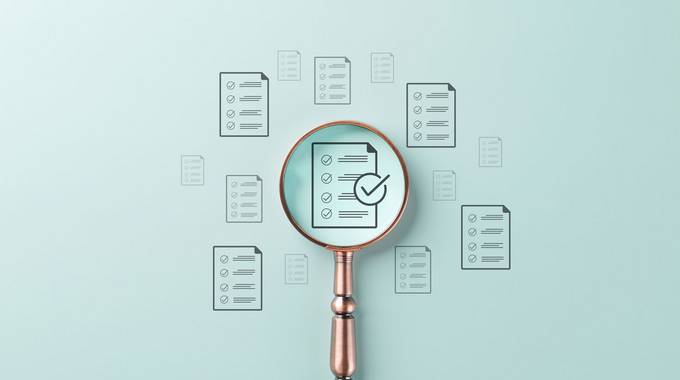 Eine Lupe ist auf ein Formular gerichtet