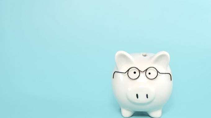 Sparschwein mit Brille © Jirawadee - stock.adobe.com Sprachwein mit Brille vor blauem Hintergrund