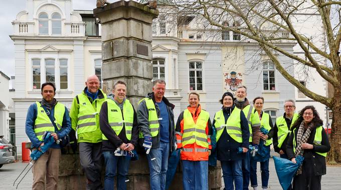 Das Team der Stadtverwaltung in Warnwestern und mit Zangen und Müllbeuteln vor dem Rathaus