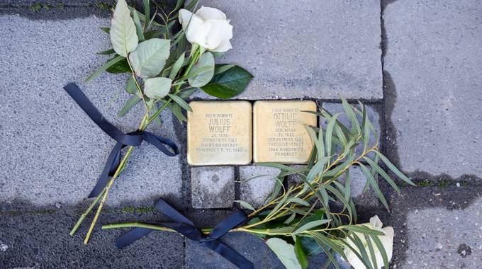 Zwei Stolpersteine mit weißen Rosen