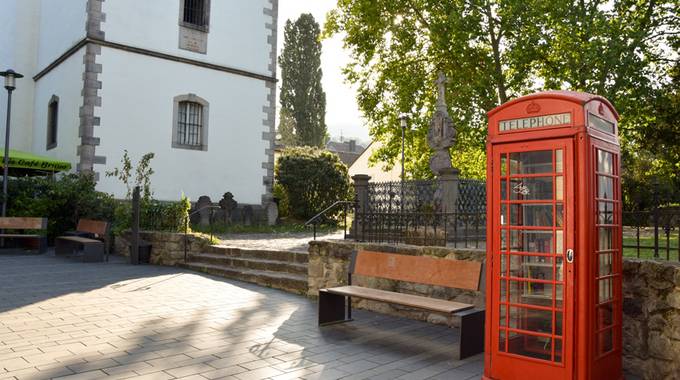 Telefonzelle als offener Bücherschrank in der Altstadt von Königswinter. Der Bücherschrank steht neben Haus Bachem und der Kirche St. Remigius TelefonzelleAltstadt web