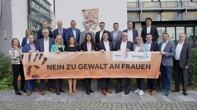 Bürgermeisterinnen und Bürgermeister bzw. deren Vertetungen, Landrat, Kreisdirektorin, Regierungspräsident, Kreisgleichstellungsbeauftragte vor der Orangefar-bigen Bank am Kreishaus