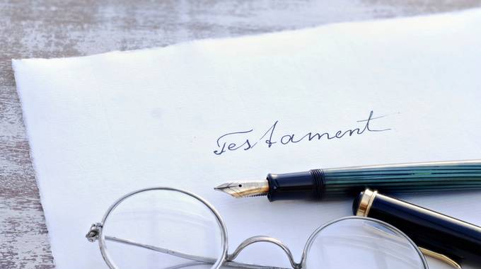 Symbolbild: Briefumschlag mit Aufdruck "Testament", Füller und Brille