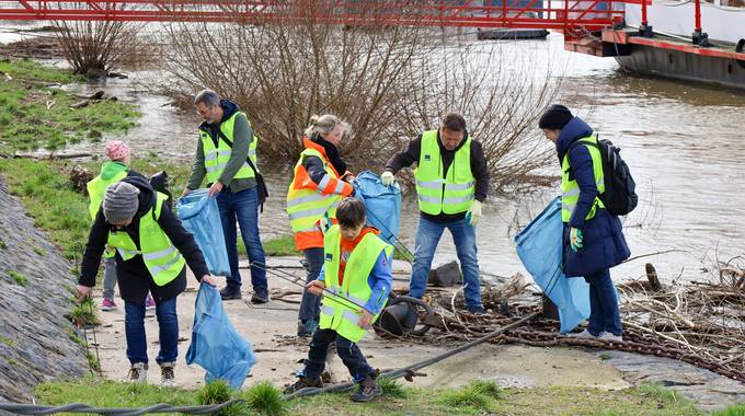 Am Rheinufer Königswinter-Altstadt wurde durch das Hochwasser Einiges angeschwemmt. Bürgermeister Lutz Wagner, Dezernentin Heike Jüngling und Mitarbeitende mit Kindern sammeln den Müll ein.