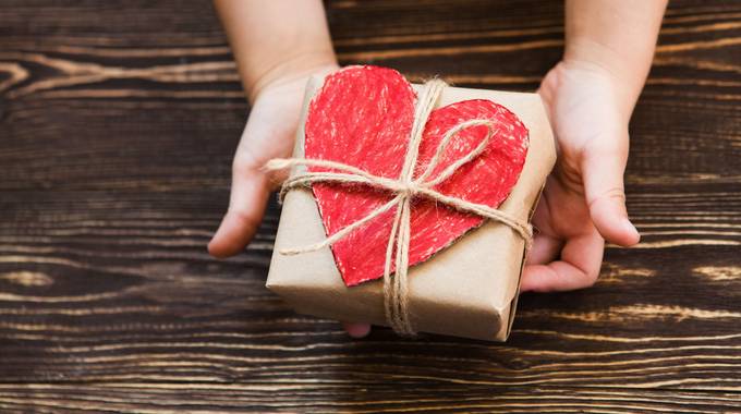 Preisträger für Ehrenamtspreis gesucht © ulza - stock.adobe.com Eine Kinderhand hält ein Paket mit einem roten Herzen