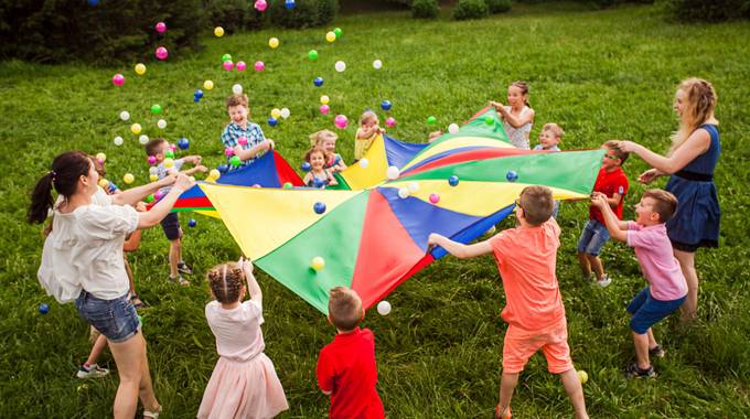 Kinder spielen auf einer Wiese im Kreis